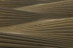 Abstract wooden structure with overlapping beams creating an intricate geometric pattern.