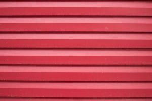 Close-up shot of a red corrugated metal surface providing a textured background.
